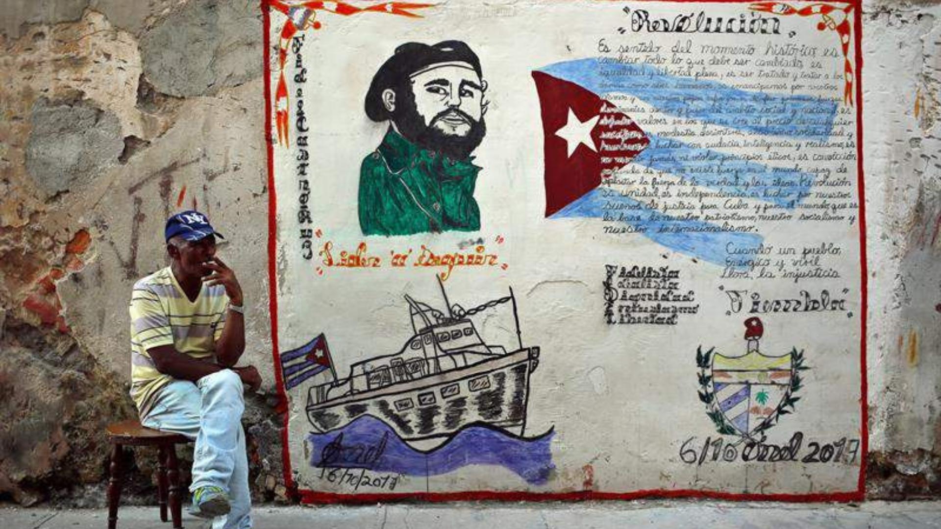 Cubano frente a un mural político sobre Fidel Castro. Foto: EFE