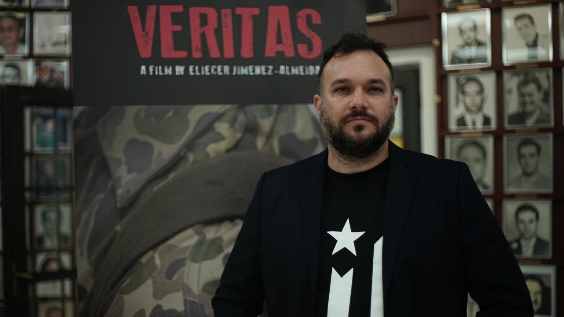 Eliecer Jiménez Almeida frente a cartel de su documental Veritas