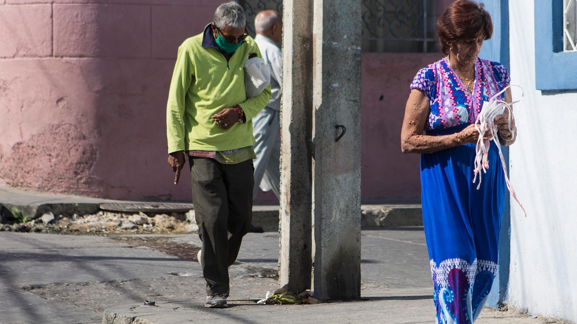 Ancianos cubanos caminan por la calle en pandemia