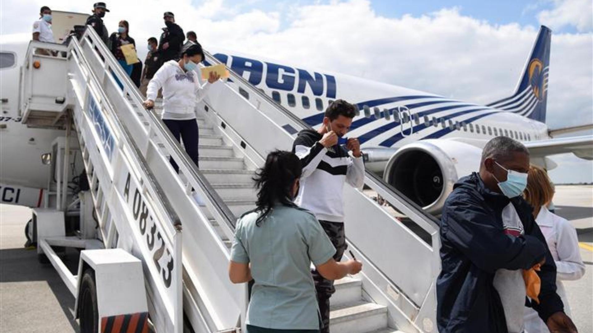 Migrantes cubanos deportados por México bajan de avión. Foto: Prensa Latina