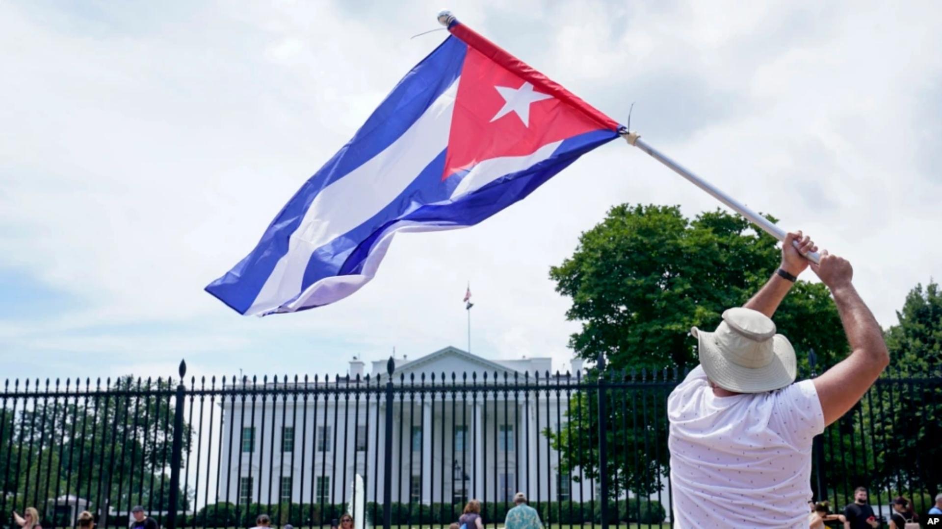 Un manifestante hace ondear una bandera cubana frente a la Casa Blanca (AP)