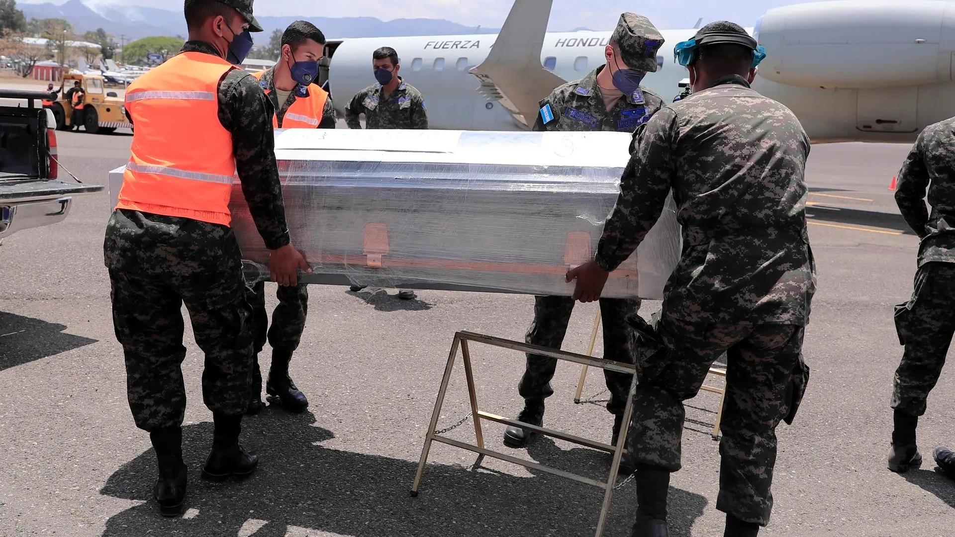 Militares hondureños transportan un ataúd con restos de un migrante