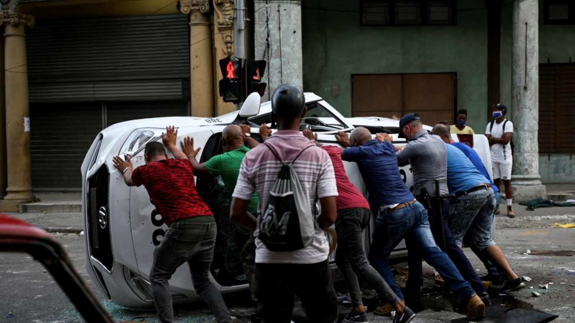 Ciudadanos encolerizados vuelcan un auto policial en La Habana el 11 de julio de 2021