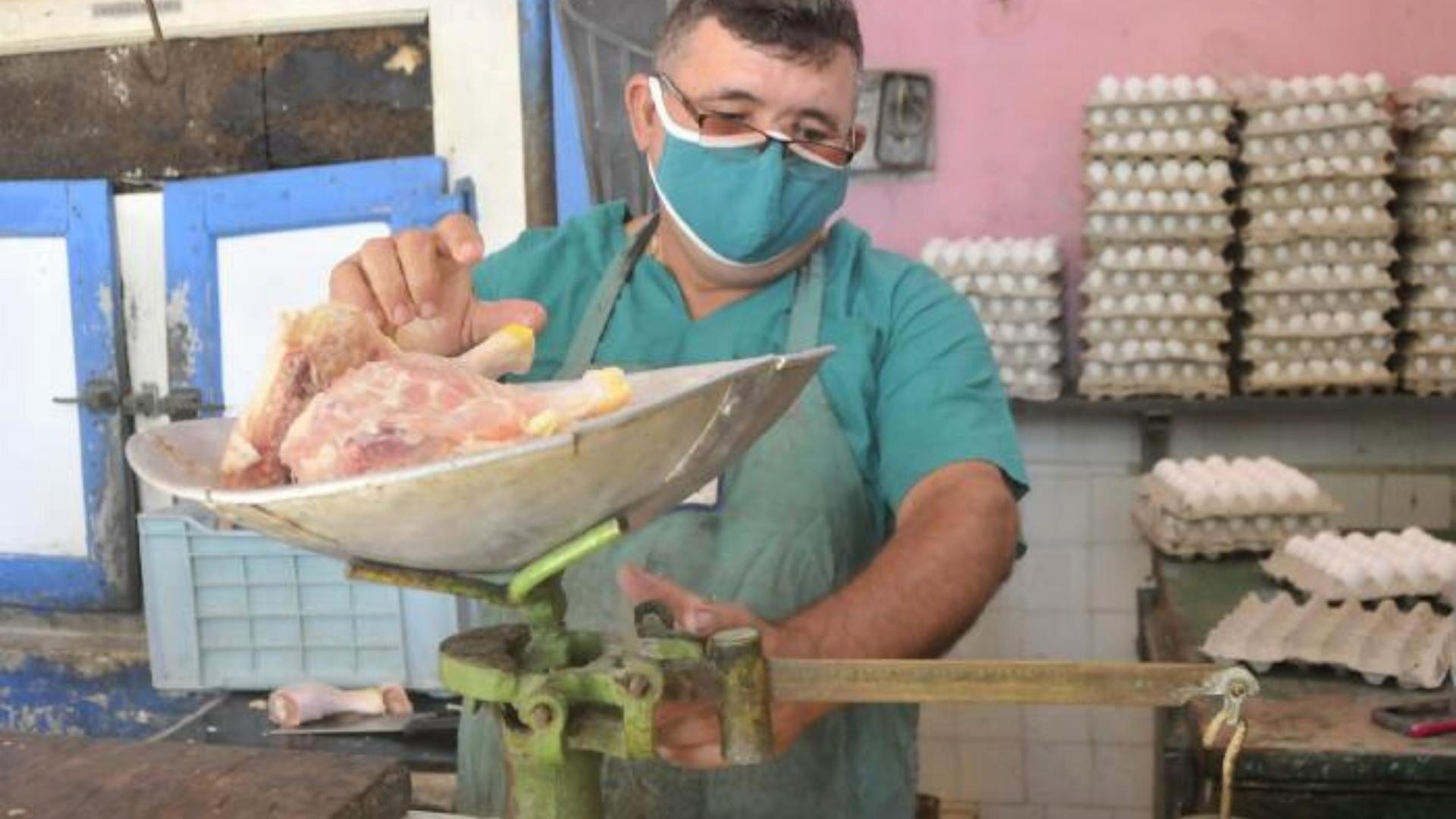 Dependiente de carnicería estatal despacha pollo. Foto: Granma