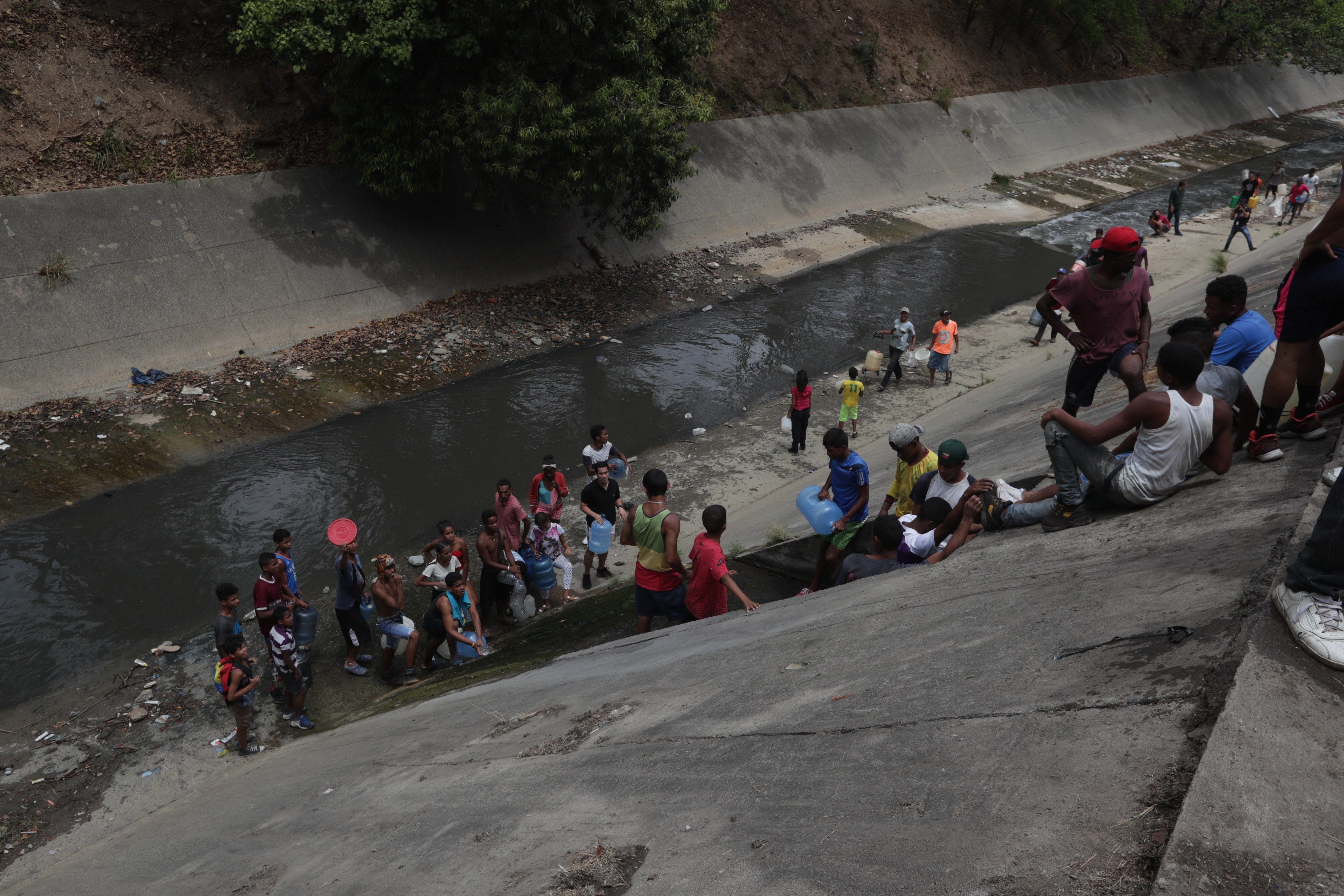 Caraqueños recogen agua en un río contaminado debido a la escasez por el apagón Personas recogen agua este lunes, en la autopista Francisco Fajardo, en Caracas (Venezuela). El apagón que sufre el país desde hace varios días no permite la llegada de agua potable a las casas de varias regiones. EFE
