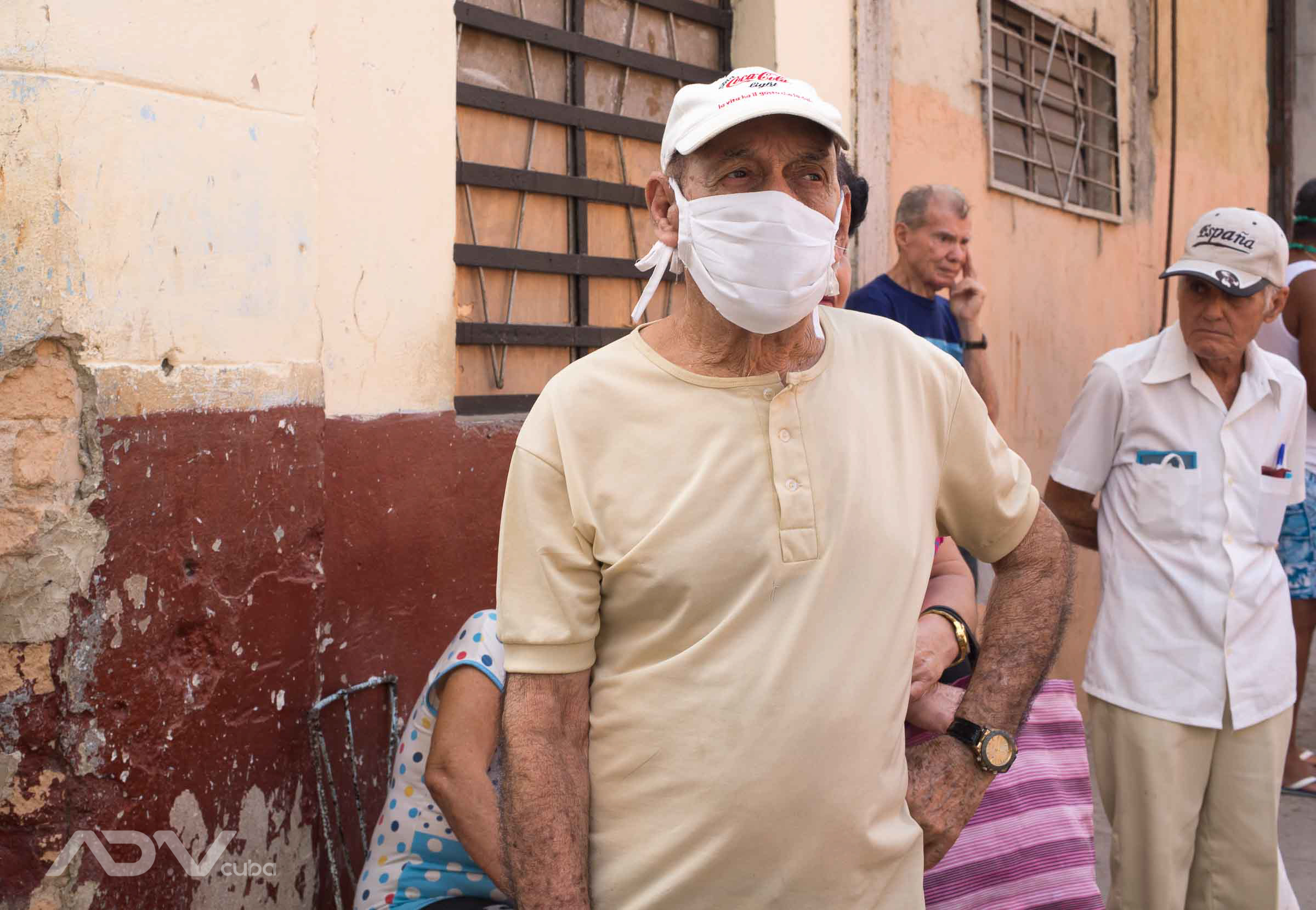 Ancianos con mascarillas, hacen cola en La Habana