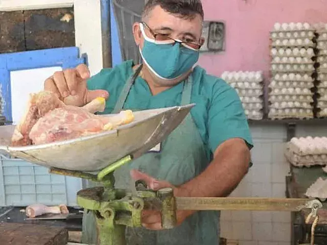 Dependiente de carnicería estatal despacha pollo. Foto: Granma