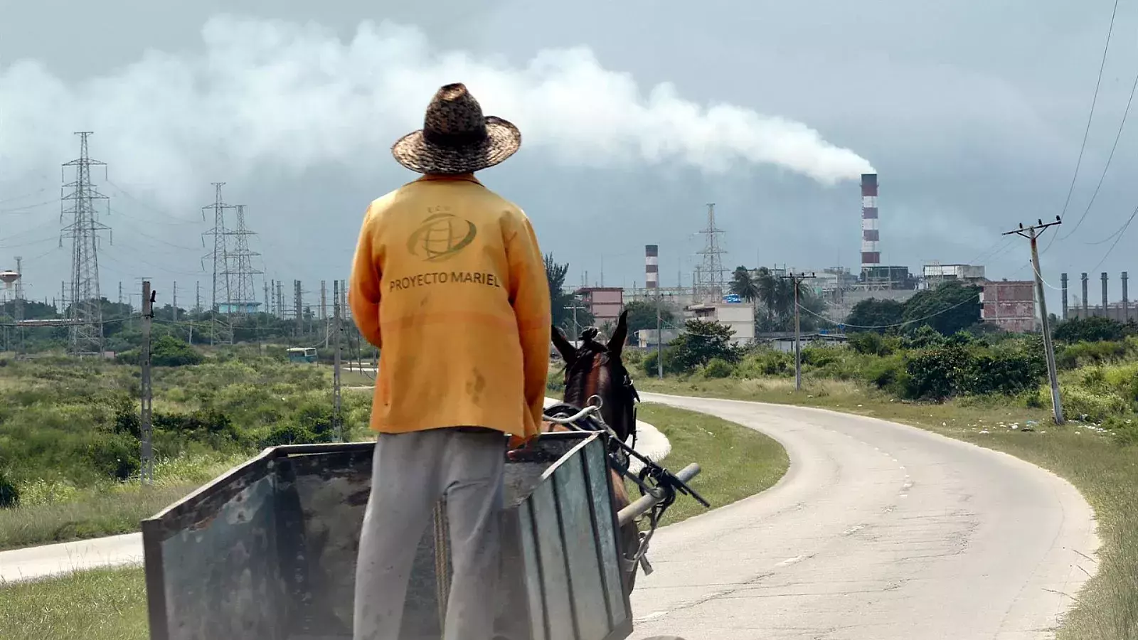Un hombre sobre una carreta de caballos mira termoeléctrica en Cuba