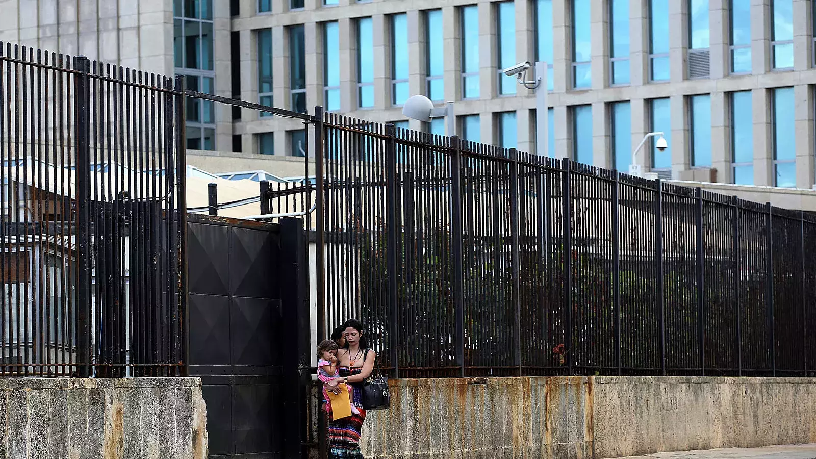 Una joven y su bebé mientras salen de la embajada de los Estados Unidos en La Habana