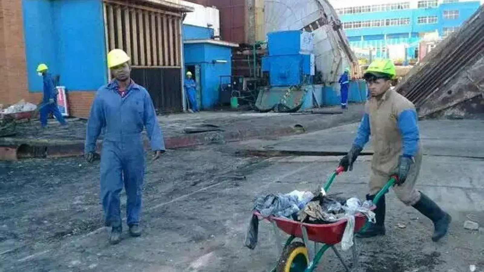 Trabajadores extraen hollín que permanece en el interior de la chimenea derrumbada