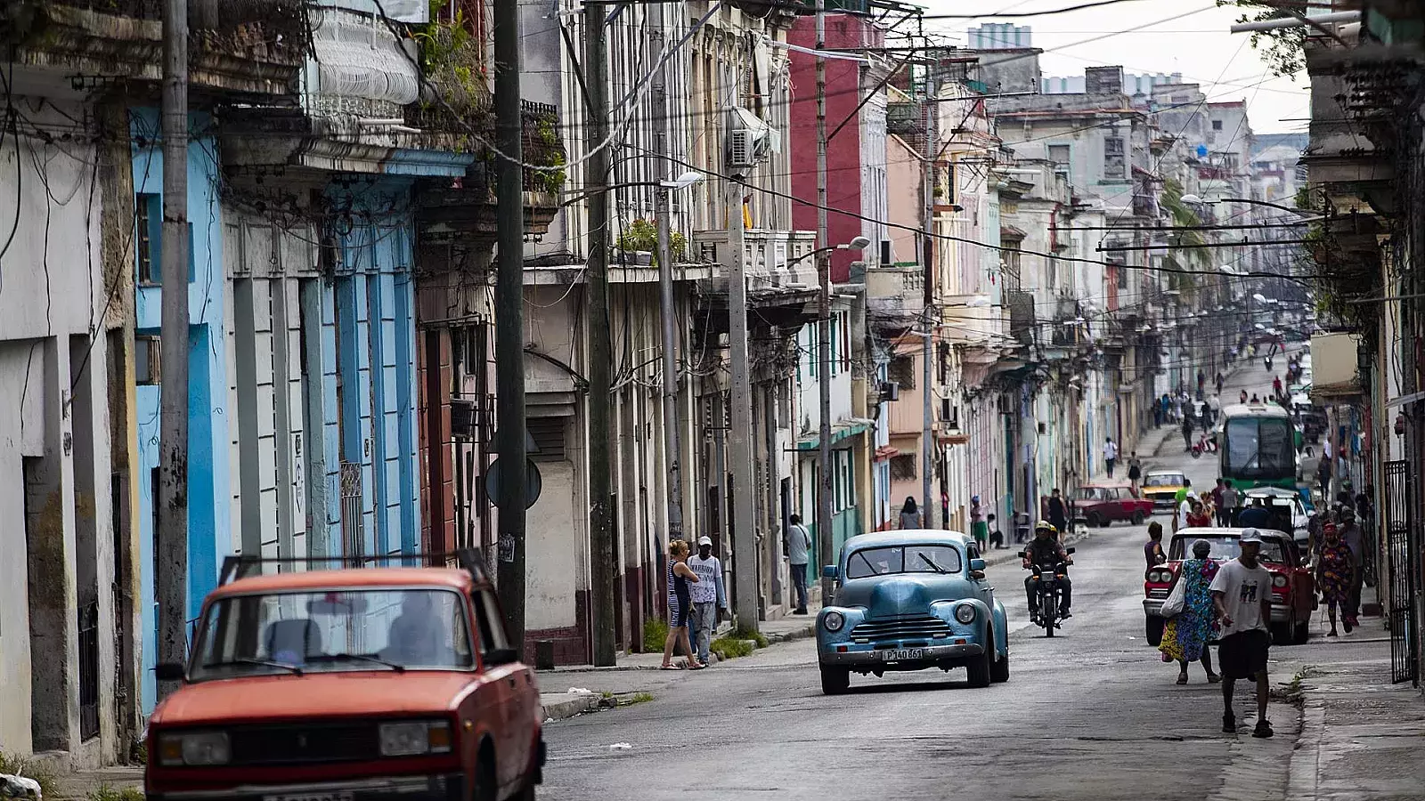 Personas y automóviles transitan por una de las calles de La Habana