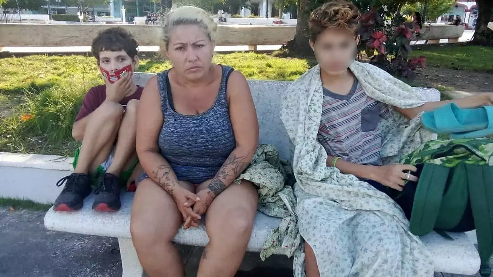 Madre cubana en la calle con sus dos hijos