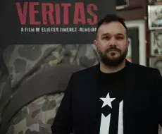 Eliecer Jiménez Almeida frente a cartel de su documental Veritas