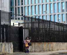 Una joven y su bebé mientras salen de la embajada de los Estados Unidos en La Habana
