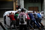 Ciudadanos encolerizados vuelcan un auto policial en La Habana el 11 de julio de 2021